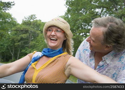 Close-up of a mid adult woman smiling with a mature man looking at her