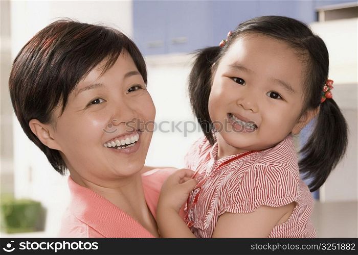 Close-up of a mid adult woman smiling with her daughter