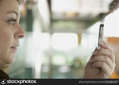 Close-up of a mid adult woman taking a picture of herself with a mobile phone