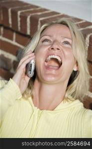 Close-up of a mid adult woman talking on a mobile phone and laughing