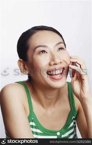 Close-up of a mid adult woman talking on a mobile phone and laughing