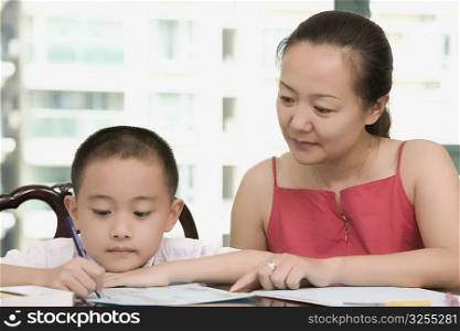 Close-up of a mid adult woman teaching her son