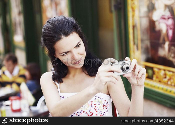 Close-up of a mid adult woman using a digital camera