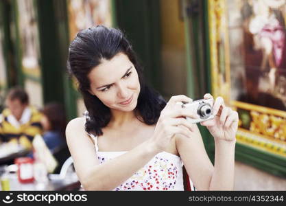 Close-up of a mid adult woman using a digital camera