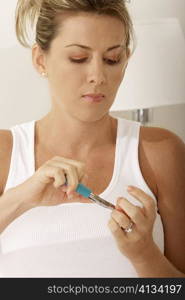 Close-up of a mid adult woman using a nail clipper