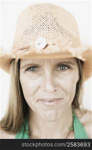 Close-up of a mid adult woman wearing a straw hat