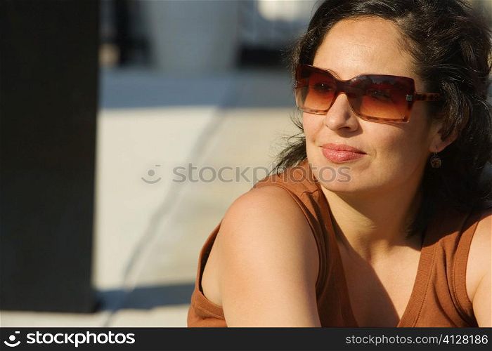 Close-up of a mid adult woman wearing sunglasses and smiling