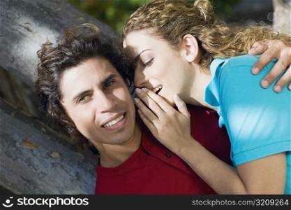 Close-up of a mid adult woman whispering into a mid adult man&acute;s ear