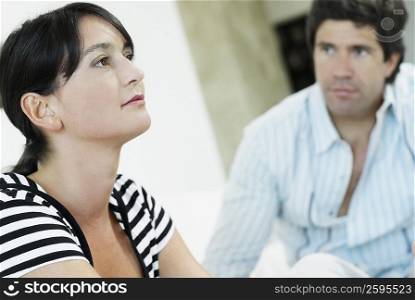 Close-up of a mid adult woman with a mid adult man looking at her