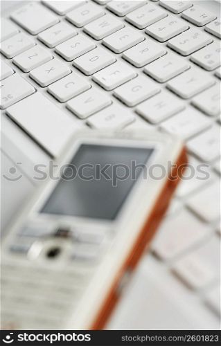Close-up of a mobile phone on a laptop
