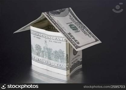 Close-up of a model home made from US paper currency