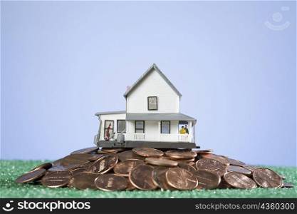 Close-up of a model home on a pile of coins