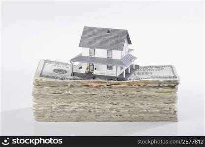 Close-up of a model home on the top of US dollar bills