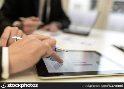 Close-up of a modern business team using tablet computer to work with financial data