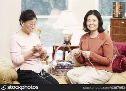 Close-up of a mother and her daughter knitting