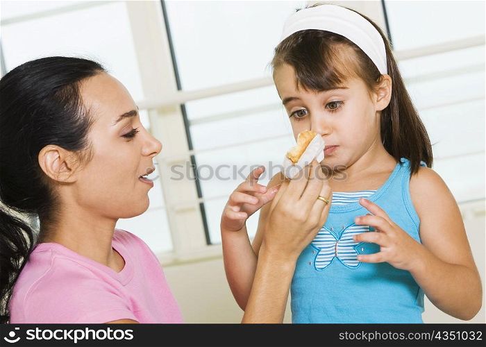 Close-up of a mother feeding her daughter