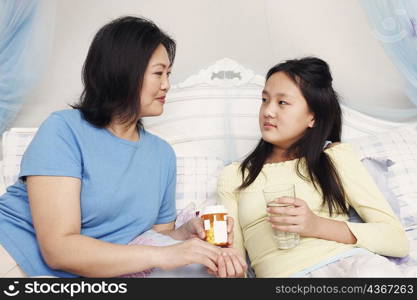 Close-up of a mother giving her daughter medicine