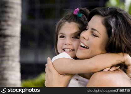 Close-up of a mother hugging her daughter