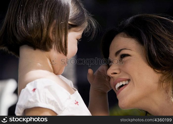 Close-up of a mother with her daughter smiling