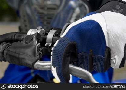 Close-up of a motocross rider&acute;s hand on the handlebar of a motorcycle