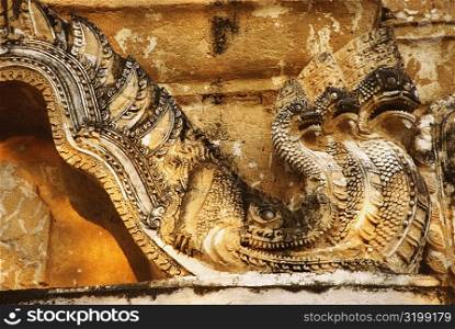 Close-up of a multi-headed dragon carved on a stone wall, Wat Si Sawai, Sukhothai, Thailand