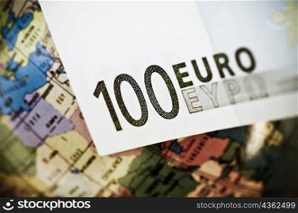 Close-up of a one hundred euro banknote with a globe