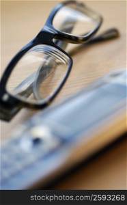 Close-up of a pair of eyeglasses with a mobile phone