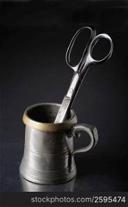 Close-up of a pair of scissors in a cup