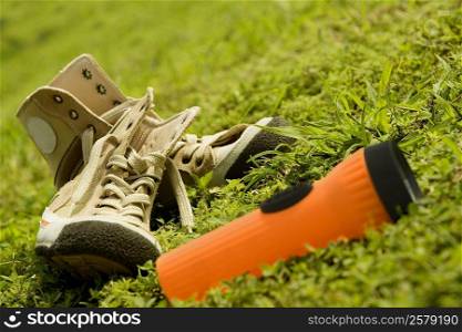 Close-up of a pair of shoes with a flashlight on the grass