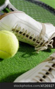 Close-up of a pair of sports shoes with a tennis racket and a tennis ball