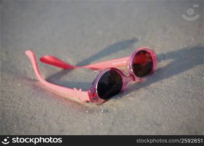 Close-up of a pair of sunglasses on the beach
