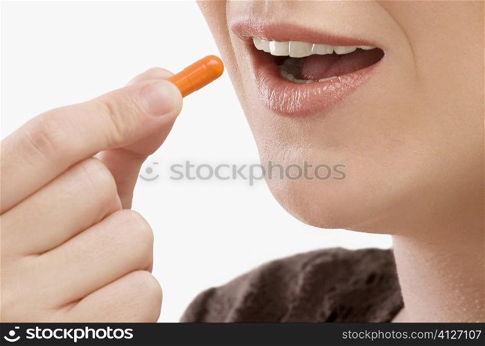 Close-up of a patient taking a capsule