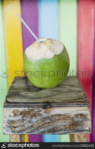 Close-up of a peeled coconut with a drinking straw