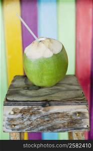 Close-up of a peeled coconut with a drinking straw