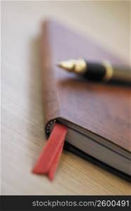 Close-up of a pen and a diary on the table