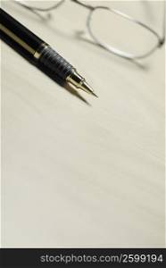 Close-up of a pen and eyeglasses on the table
