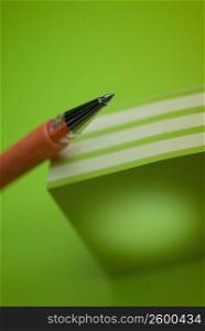 Close-up of a pen on a stack of colored post-it notes