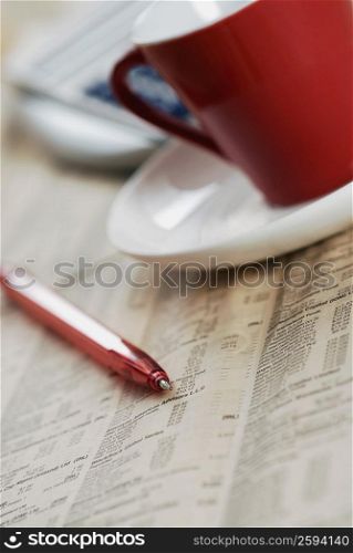 Close-up of a pen with a cup and a saucer