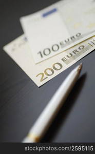 Close-up of a pen with Euro notes