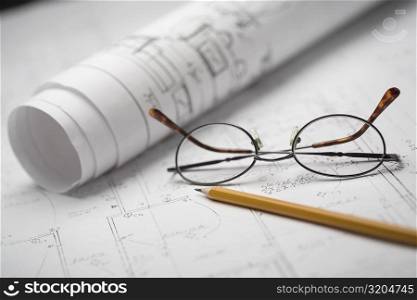 Close-up of a pencil and eyeglasses on a sheet of paper