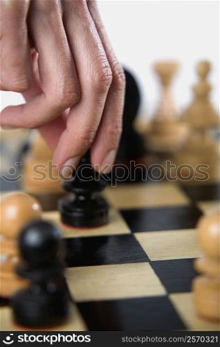Close-up of a person&acute;s finger holding a chess piece