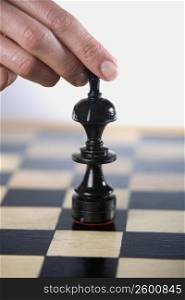 Close-up of a person&acute;s finger holding a chess piece