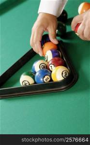 Close-up of a person&acute;s hand arranging pool balls