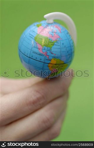 Close-up of a person&acute;s hand balancing a globe