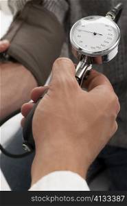 Close-up of a person&acute;s hand checking a patient&acute;s blood pressure