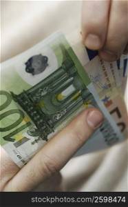 Close-up of a person&acute;s hand counting Euro banknotes