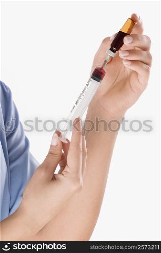 Close-up of a person&acute;s hand filling an injection from a vial