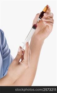 Close-up of a person&acute;s hand filling an injection from a vial