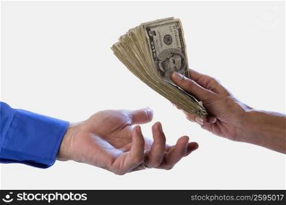 Close-up of a person&acute;s hand giving dollars to another