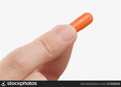 Close-up of a person&acute;s hand holding a capsule